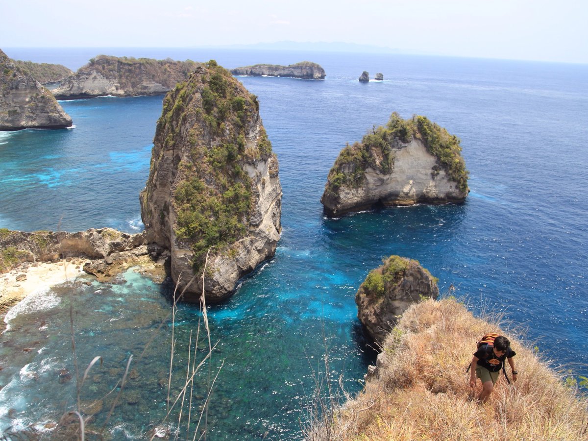Atuh Beach Nusa Penida seen through a natural rock arch with turquoise water and white sand