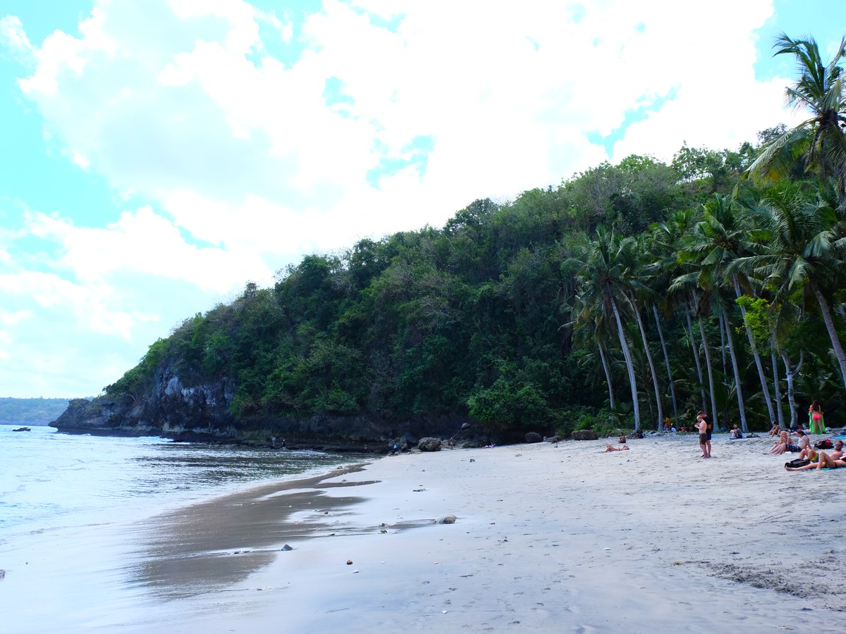 Crystal Bay beach Nusa Penida at sunset with calm water and palm trees