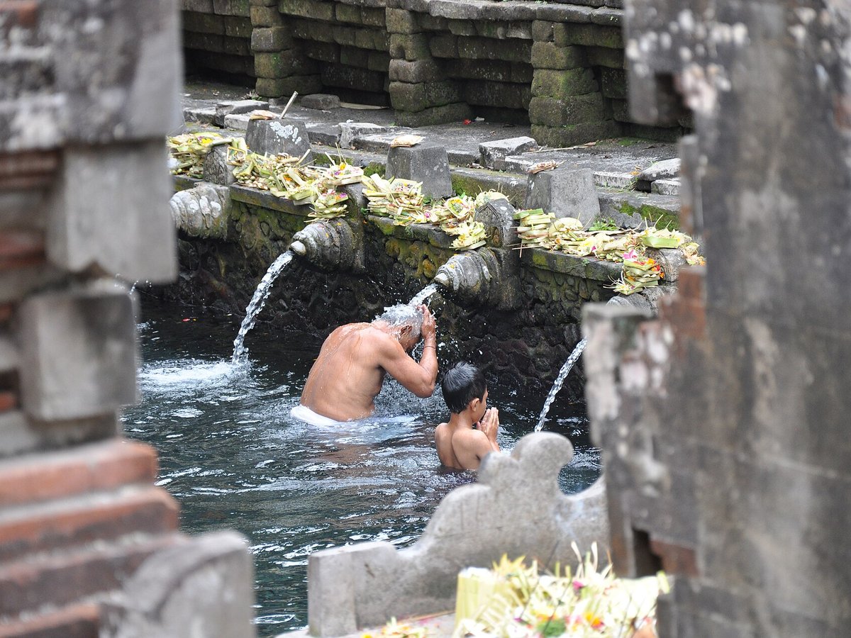 Balinese Hindu worshippers under purification water spouts at Tirta Empul temple near Ubud