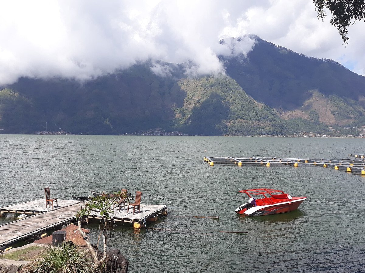 Natural hot spring pools beside Lake Batur with the volcano crater behind in Bali